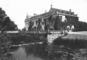 1928 view of Dauntsey House covered with ivy, with the Bristol Avon cascades outside